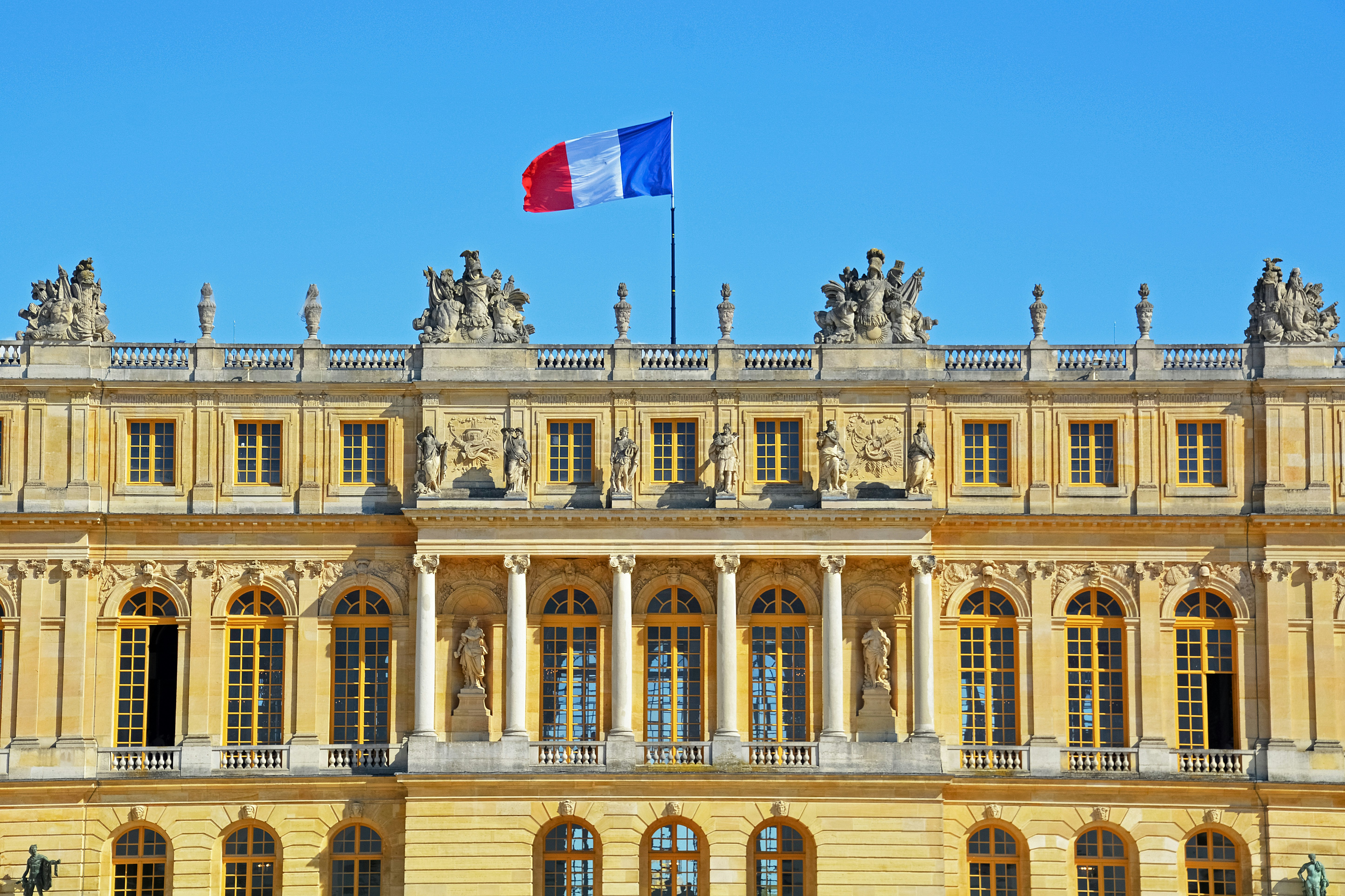 beige concrete building with flags on top during daytime